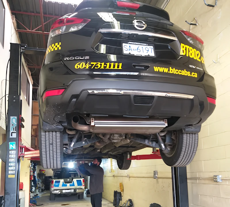 BTCabs taxi raised on a lift inside the Z&S Auto Repair shop